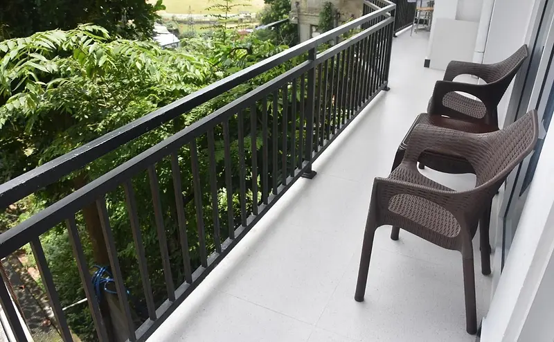 Two chairs on a private balcony overlooking trees