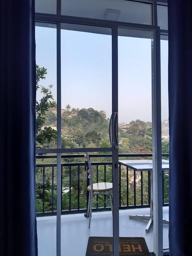 Open balcony door with a view of the hills