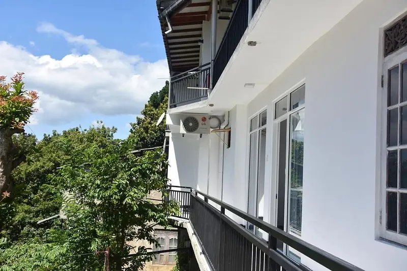 Guest house balconies and white walls among trees