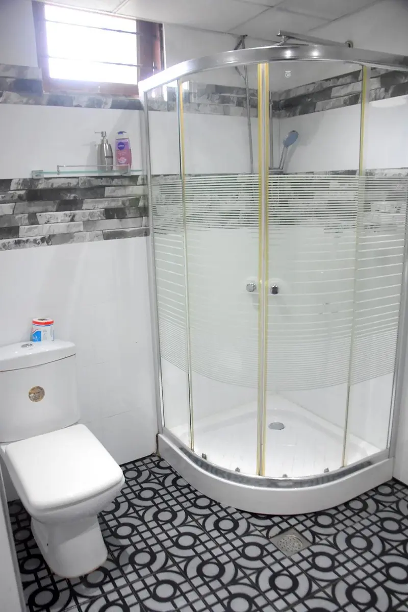Bathroom with corner shower and patterned floor