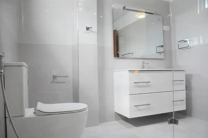 White bathroom with mirror, vanity and shower