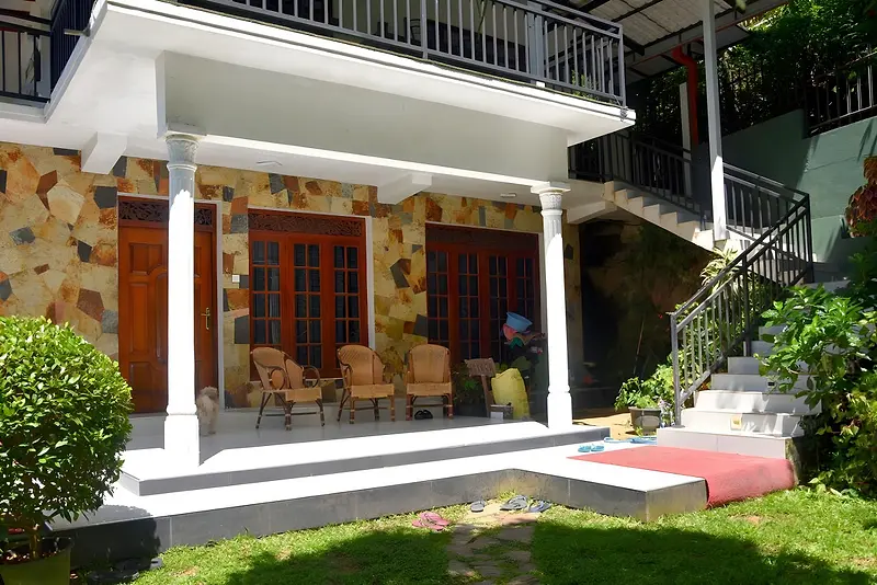 Front verandah of Cozy Homestay Kandy with stone wall cladding and garden lawn