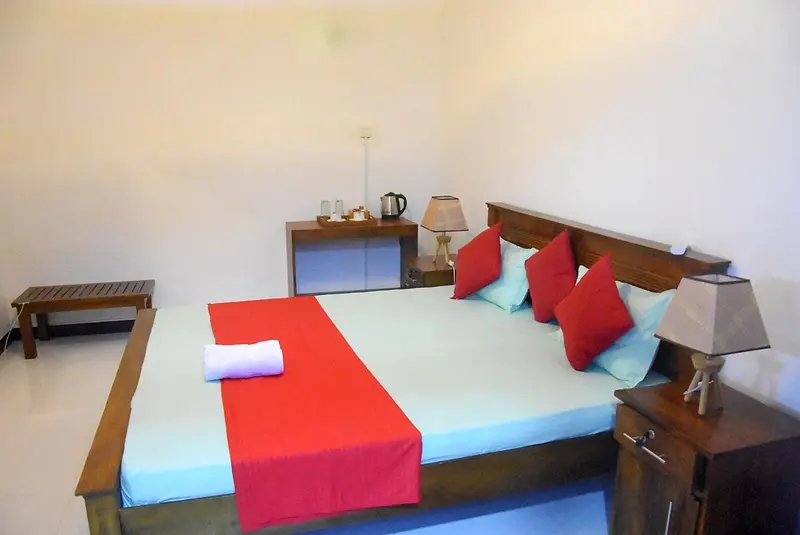 Double room with turquoise sheets and red cushions
