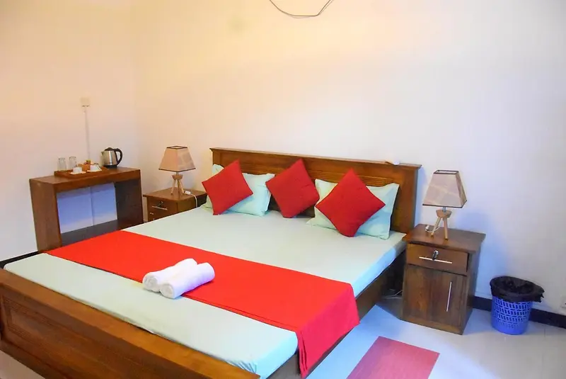 Bright double room with teak bed and red runner